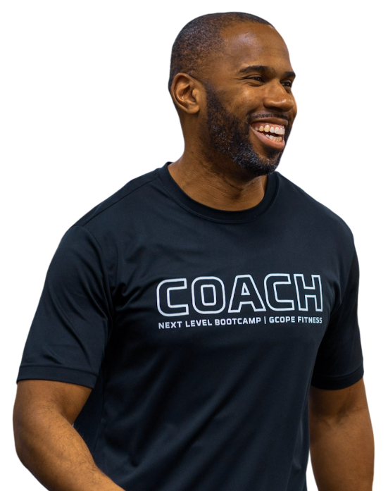 A man wearing a black coach t-shirt is smiling.