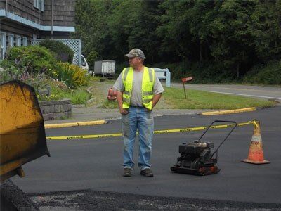 Man standing on fresh pavement - paving services in Grayland, WA