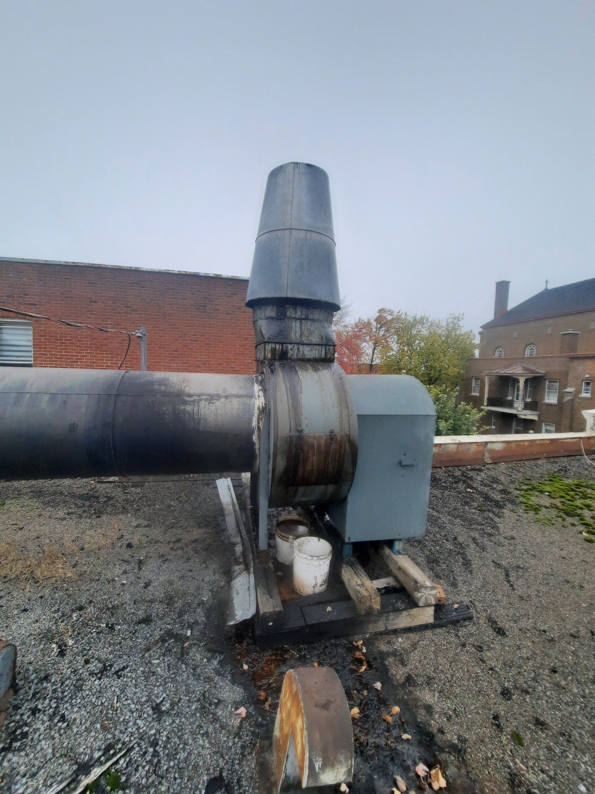 Un ventilateur est posé sur le toit d’un immeuble.