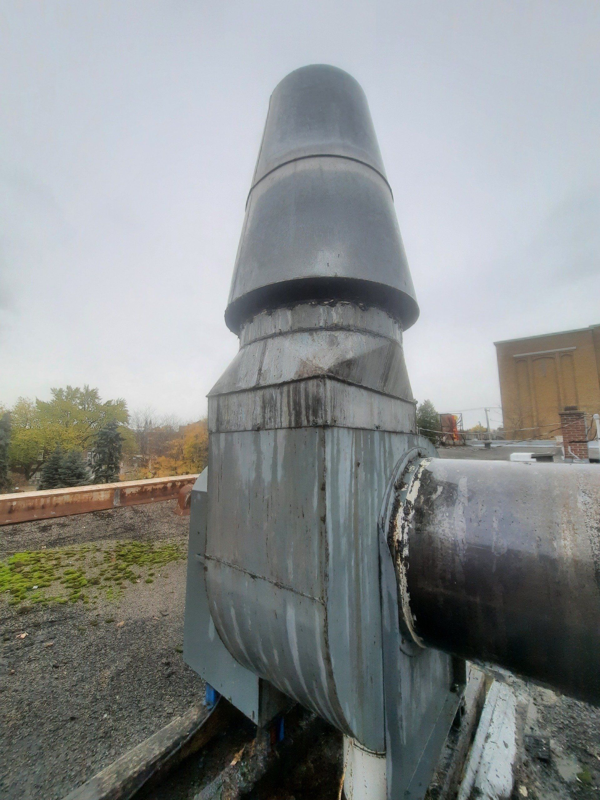 Un gros tuyau métallique surmonté d’un cône.