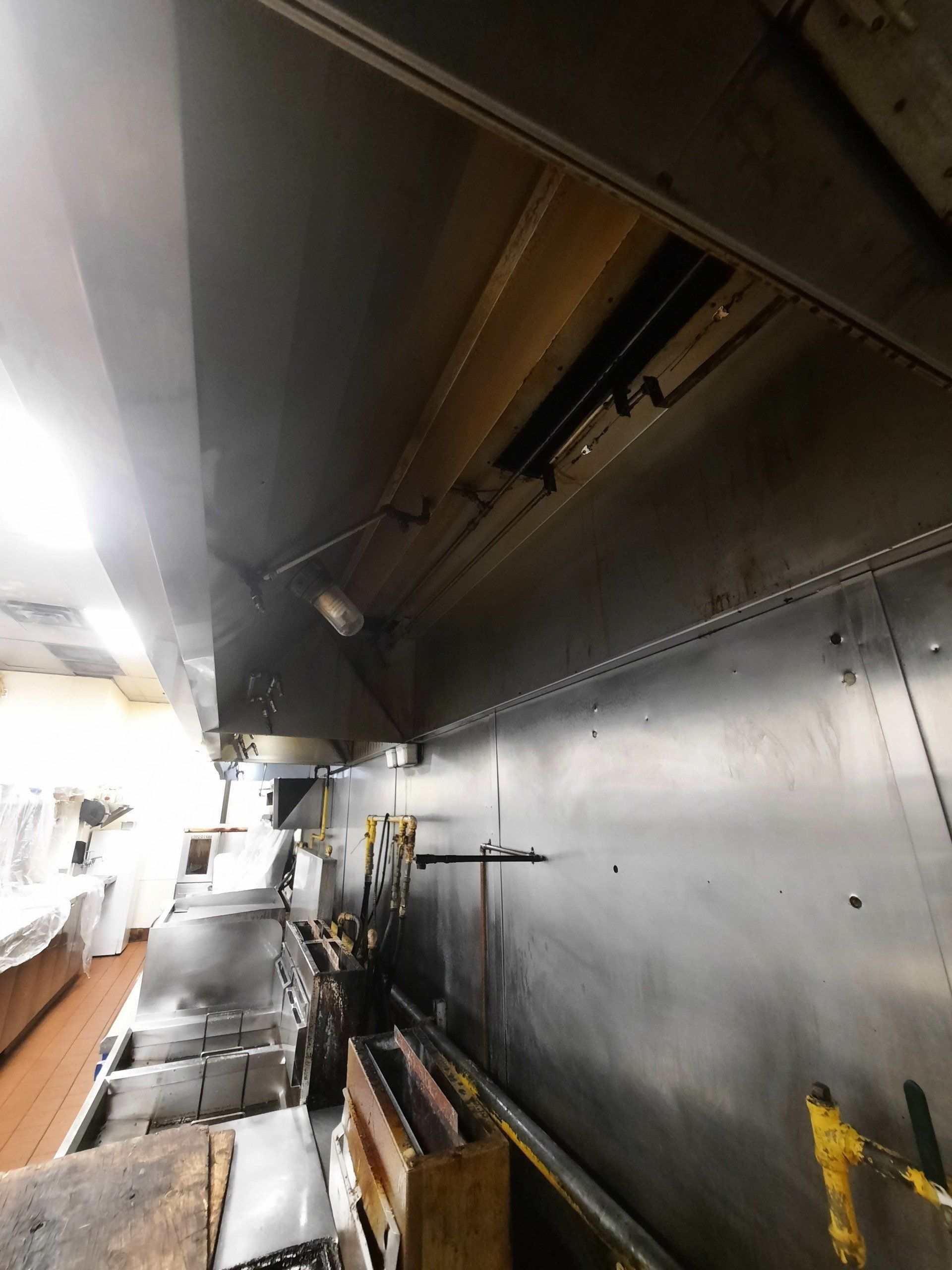 Une cuisine avec une hotte et beaucoup de casseroles et poêles