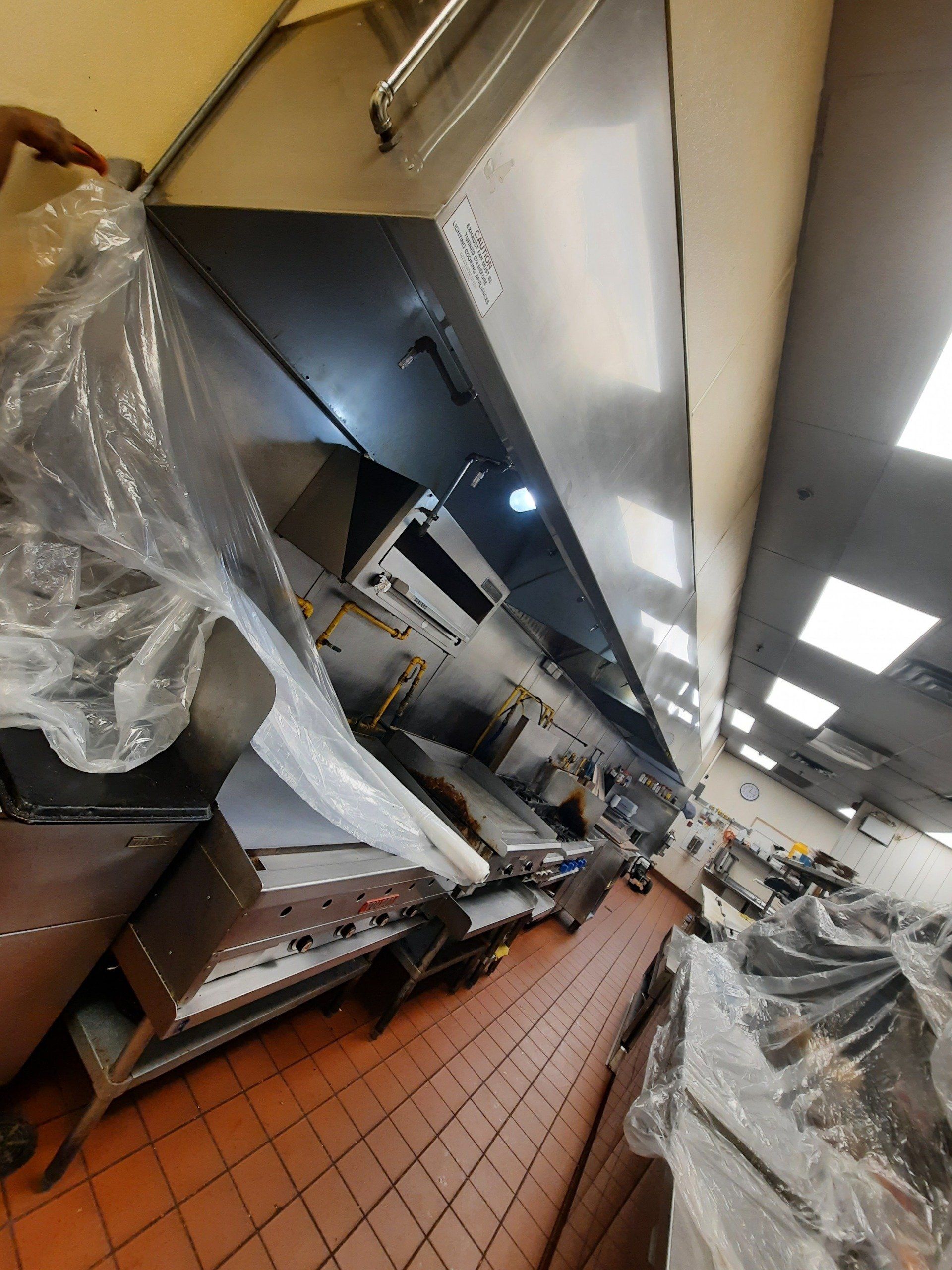 Une cuisine avec beaucoup d électroménagers et un ventilateur de plafond.