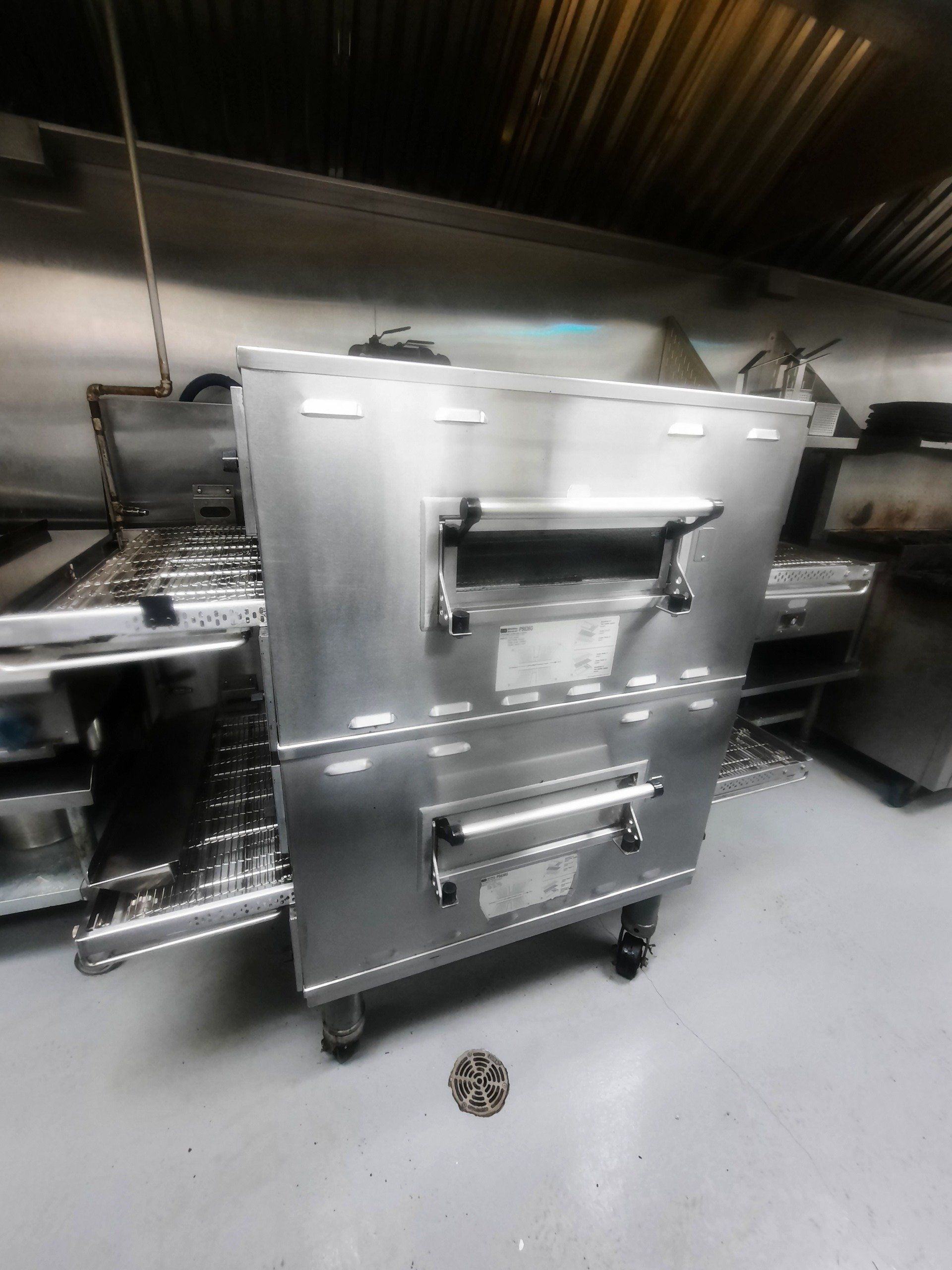 Un four en acier inoxydable est posé sur le sol dans une cuisine.