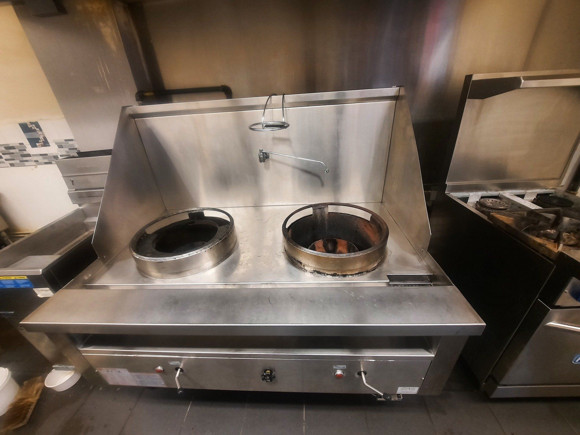 Une cuisinière en acier inoxydable avec deux casseroles dans une cuisine.