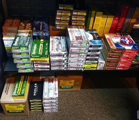 Shelves stocked with various boxes of rifle and handgun ammunition, featuring brands like Remington and Winchester.