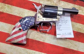 A revolver with an American flag-patterned grip resting on an American flag background with an attached price tag.