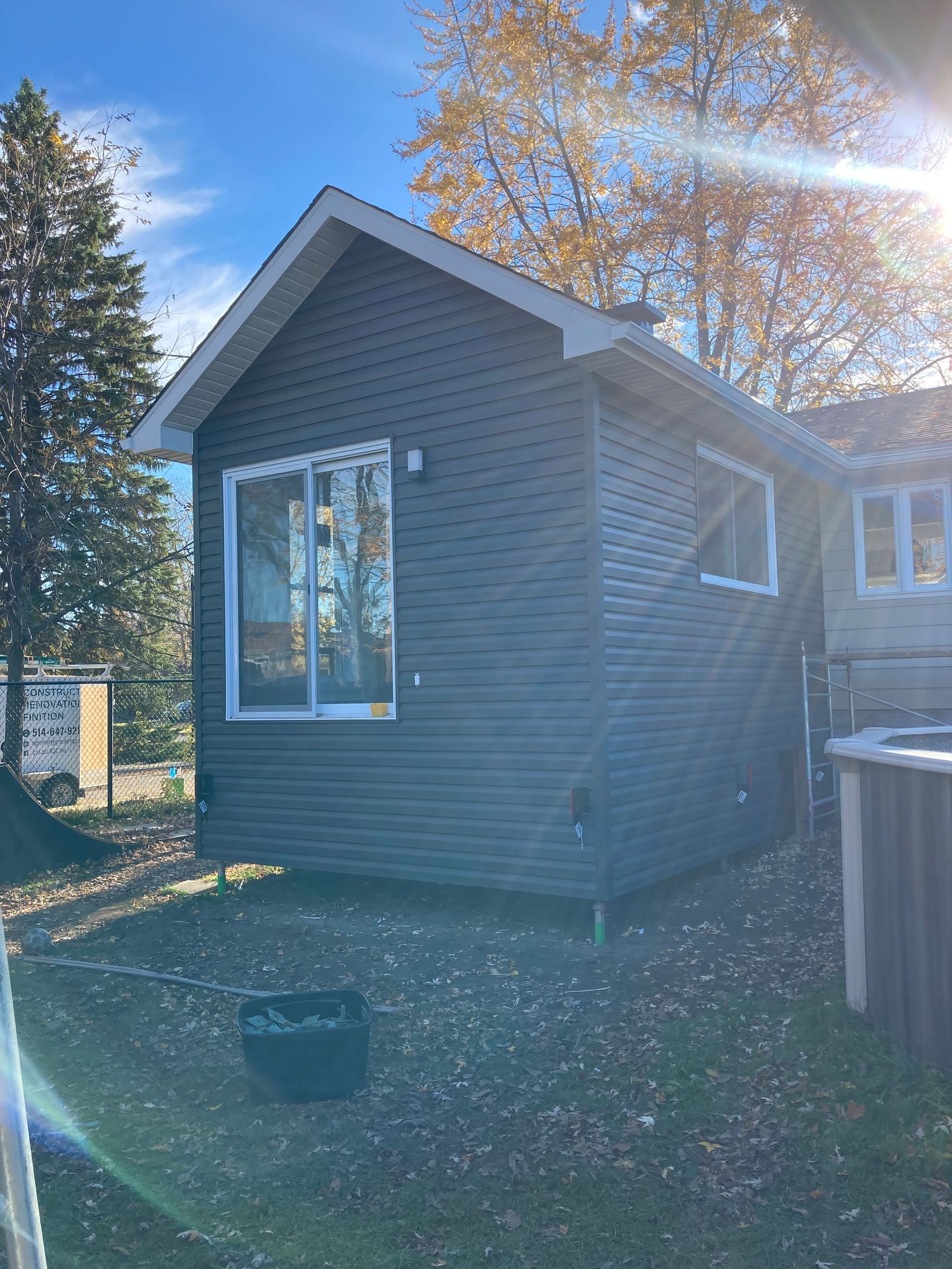 Une petite maison avec un jacuzzi dans l'arrière-cour.