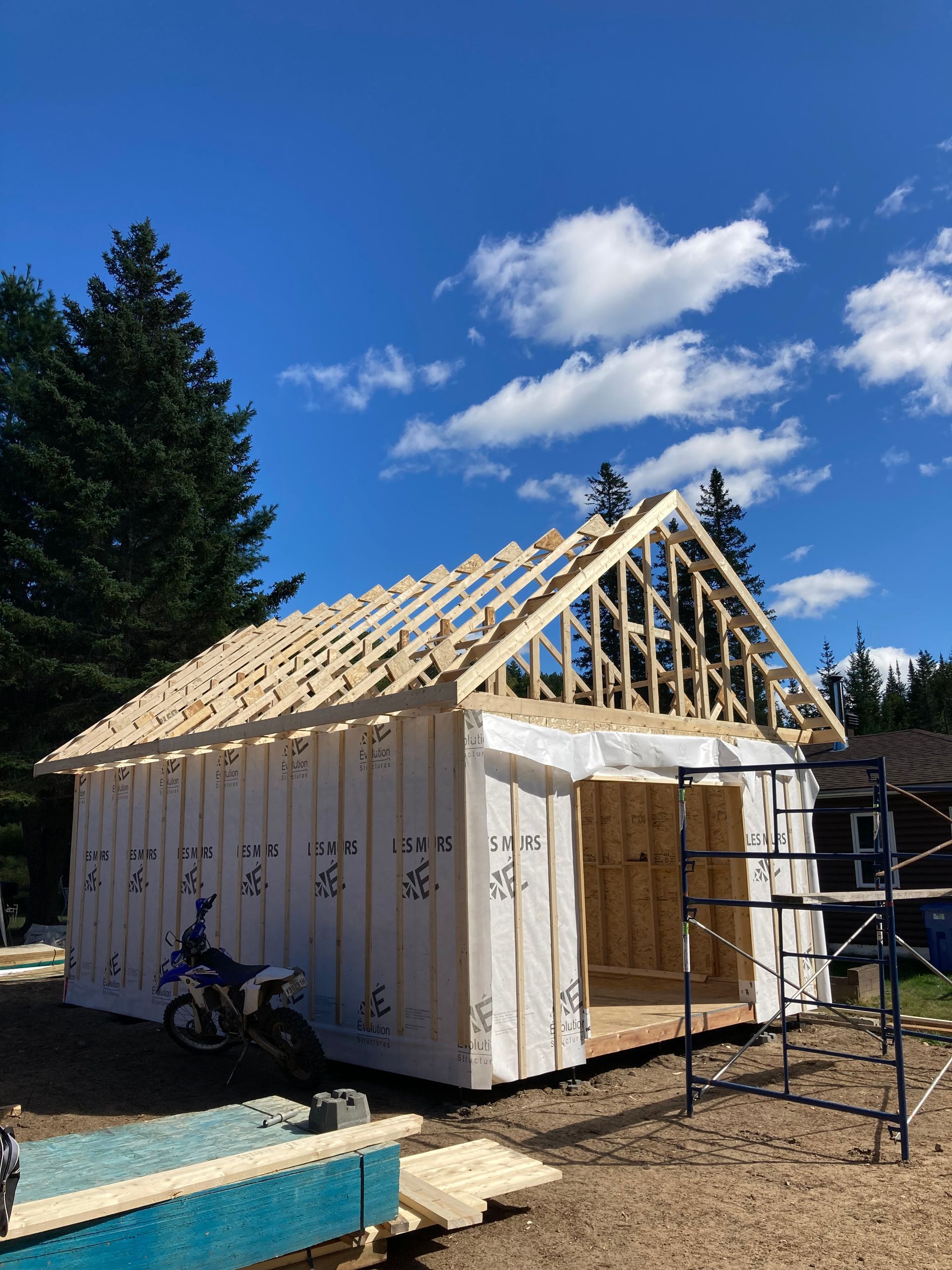 Une moto est garée devant un immeuble en construction.