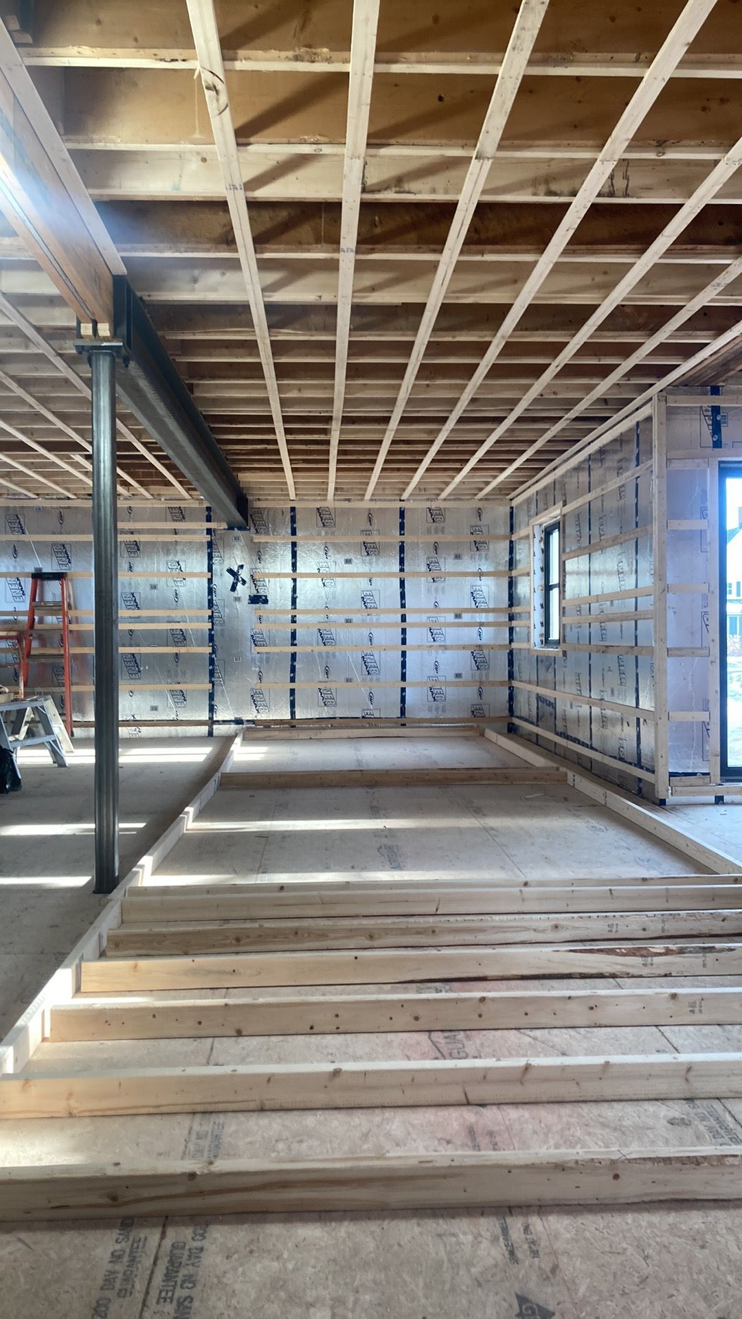 Un sous-sol en construction avec une échelle en arrière-plan.