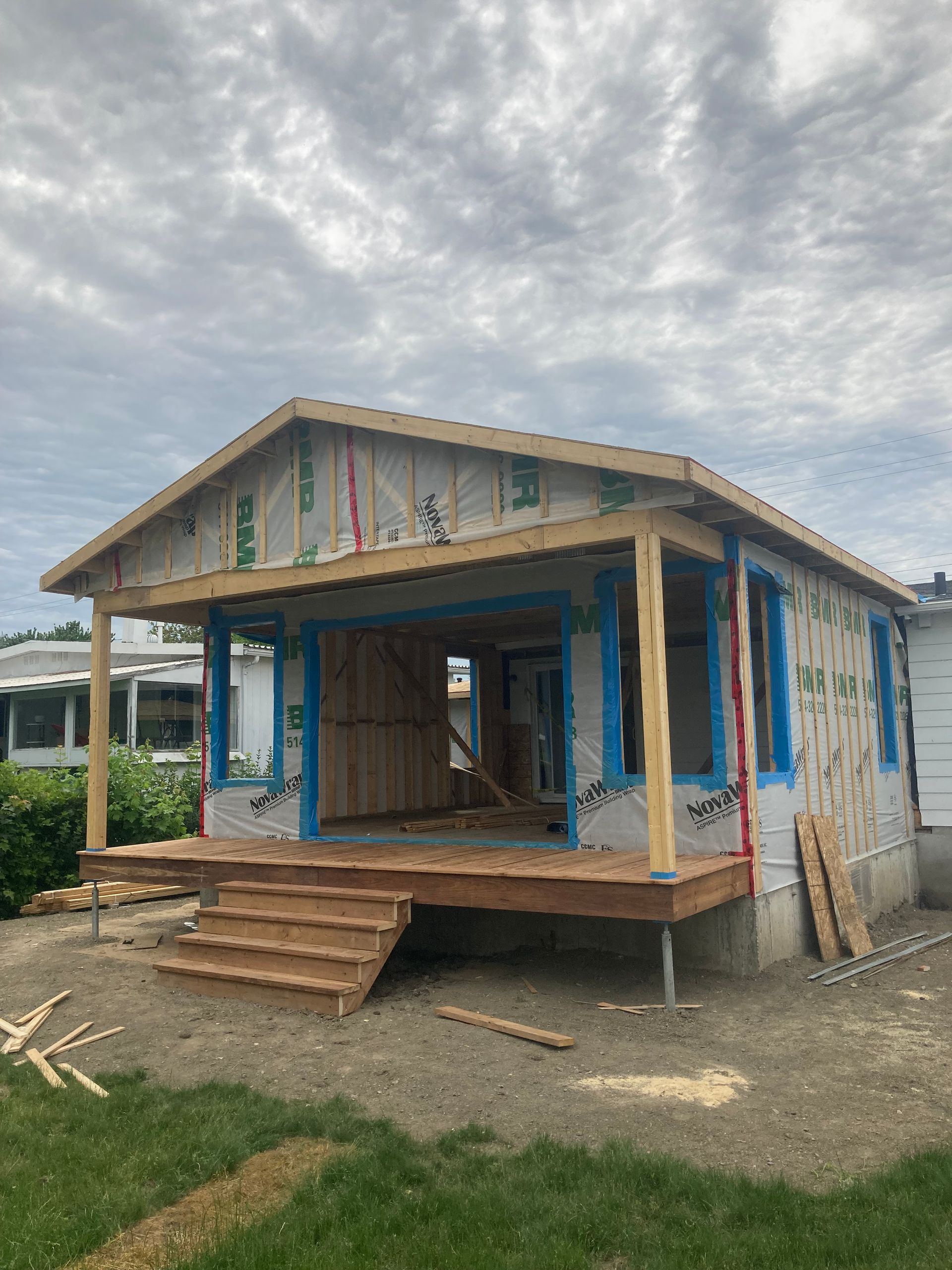 Une petite maison est en construction avec un porche et des escaliers.