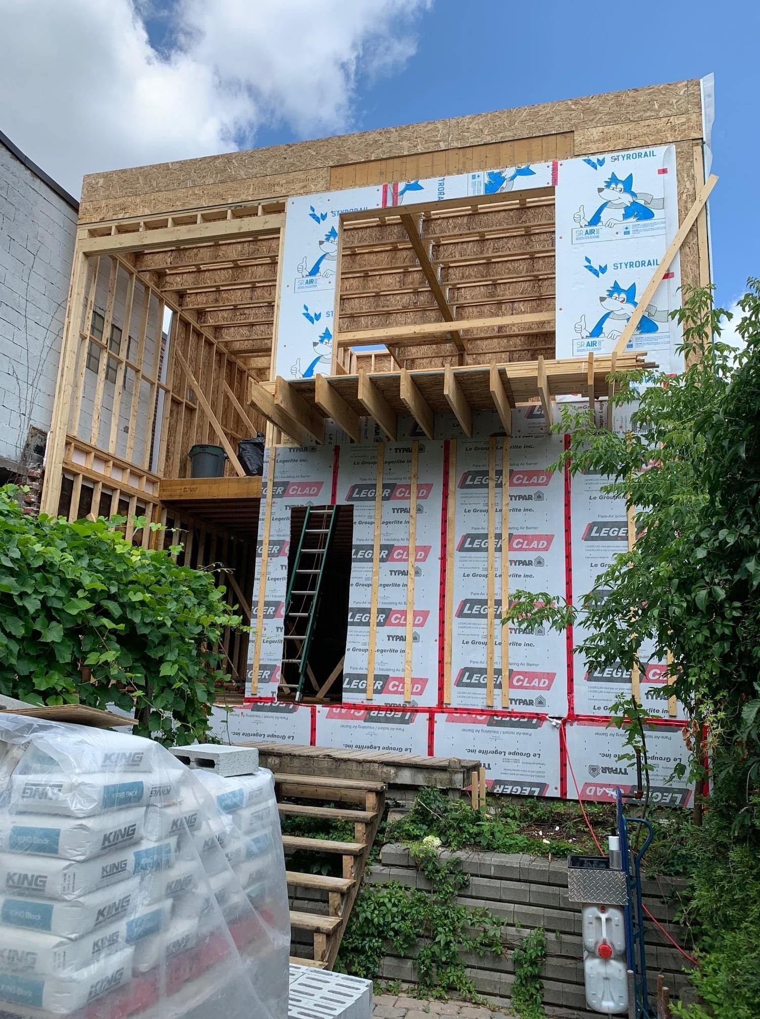 Une maison est en train d'être construite avec beaucoup de bois.