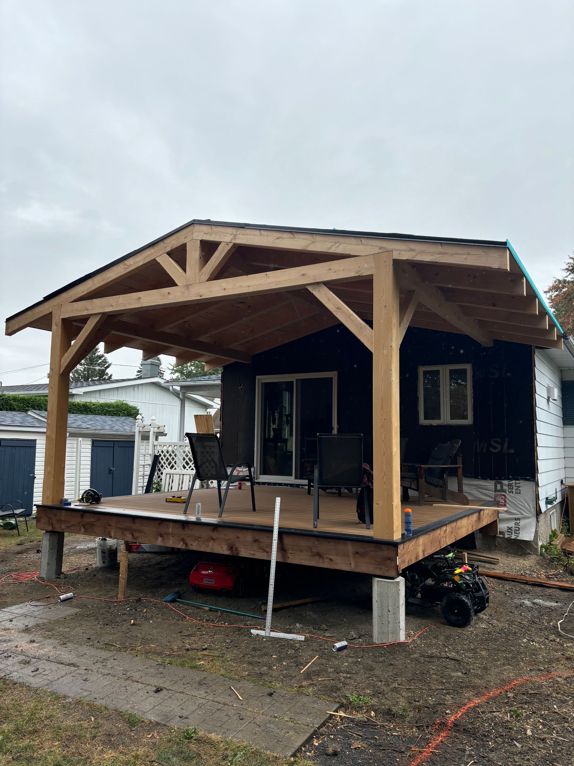 Une maison avec une terrasse en bois et un porche couvert.