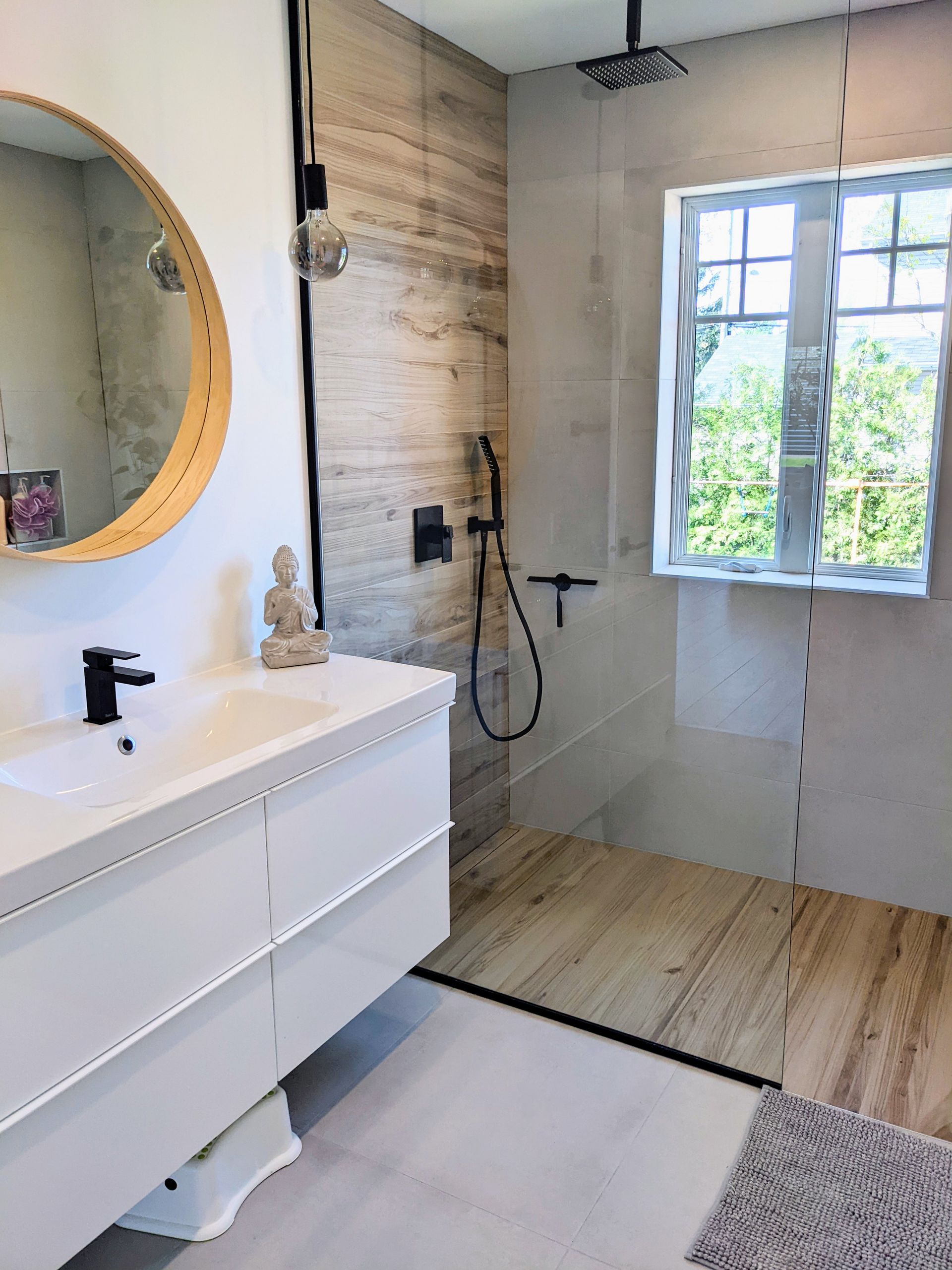 Une salle de bain avec lavabo, miroir et douche à l'italienne.