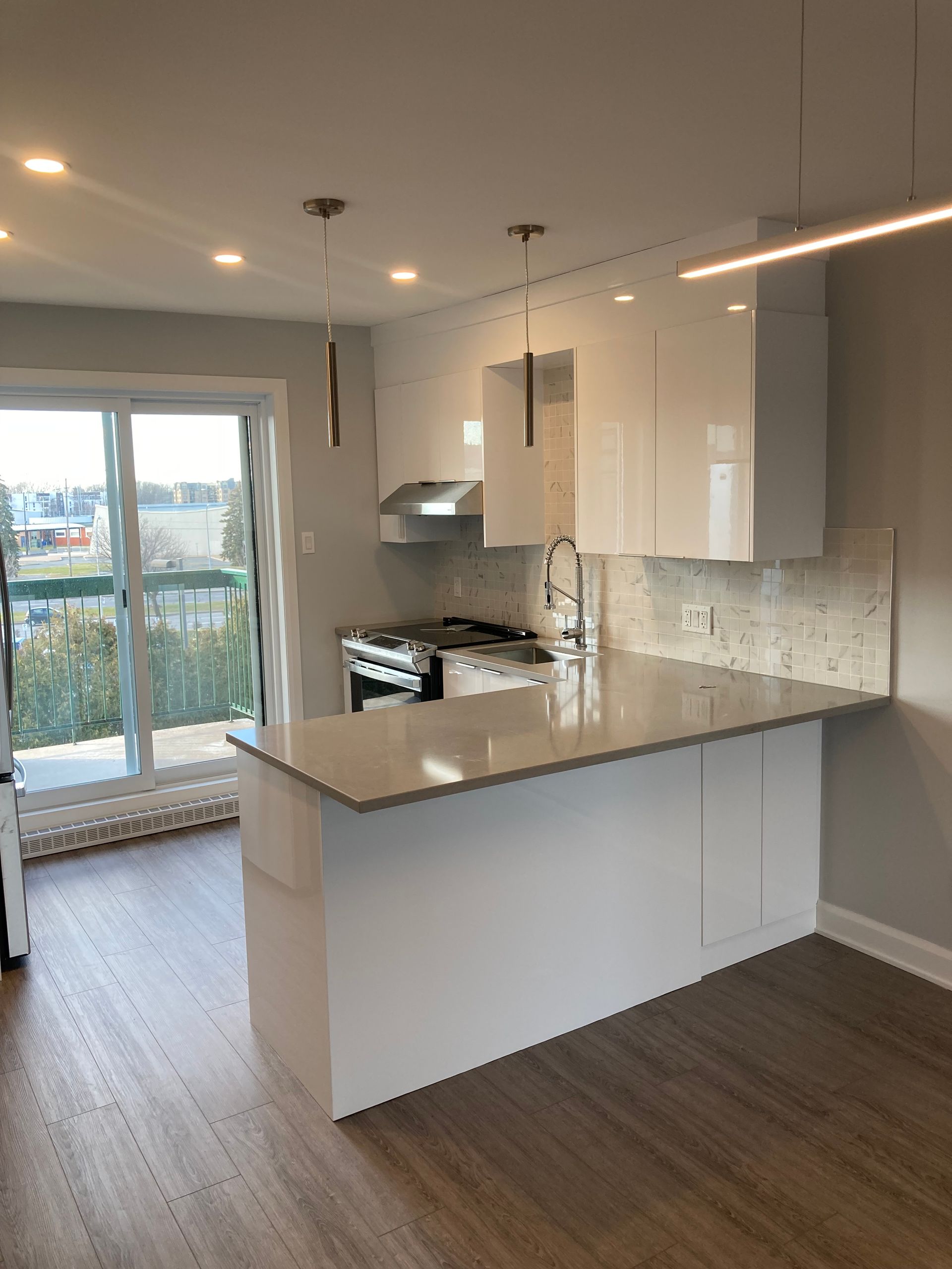 Une cuisine avec des armoires blanches et un grand îlot au milieu de la pièce.