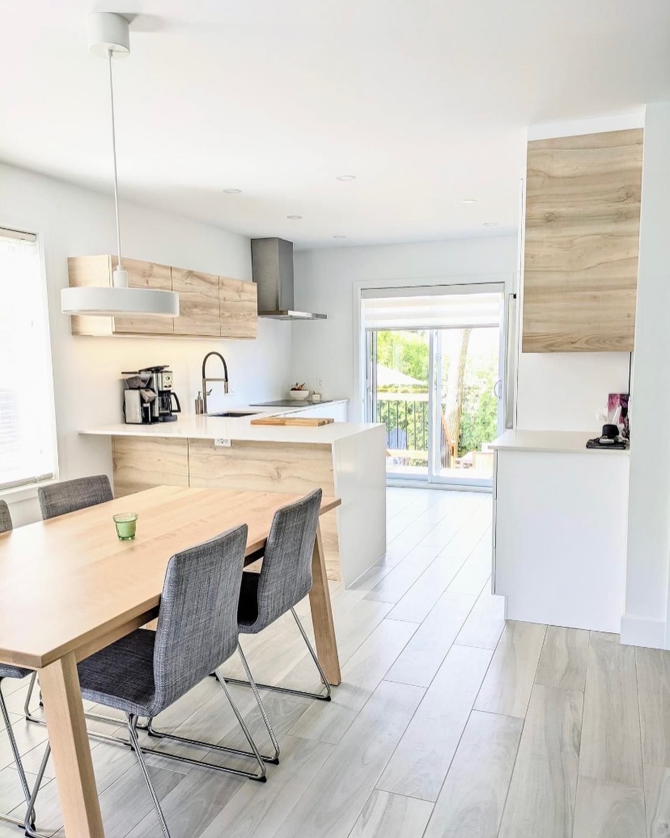 Une cuisine avec une table en bois et des chaises à l'intérieur.