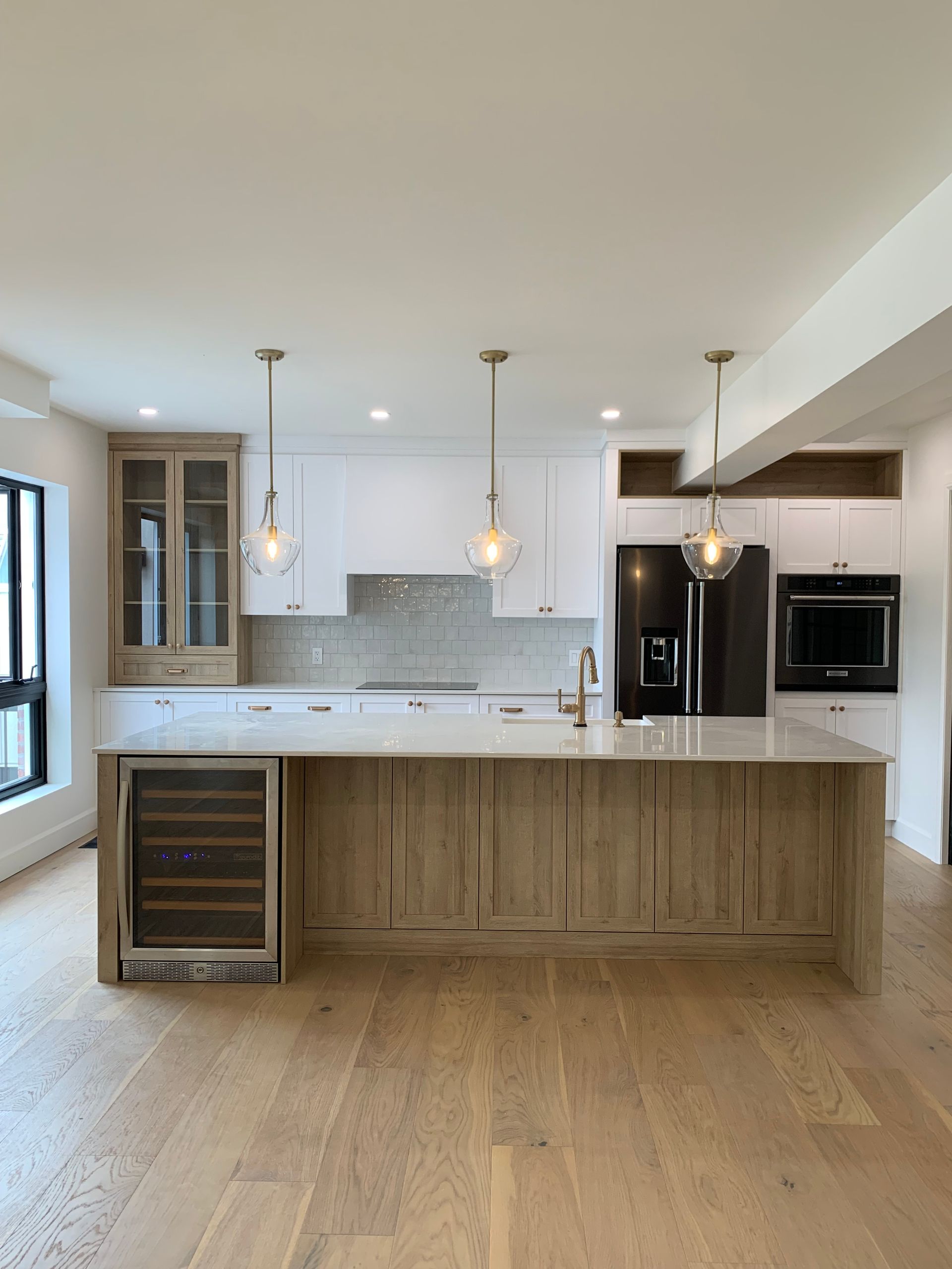 Une cuisine avec un grand îlot et un refroidisseur à vin