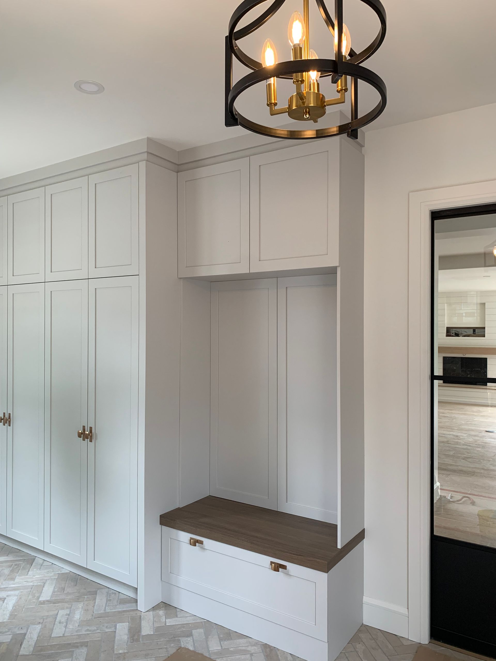 Une pièce avec des armoires blanches et un lustre suspendu au plafond.