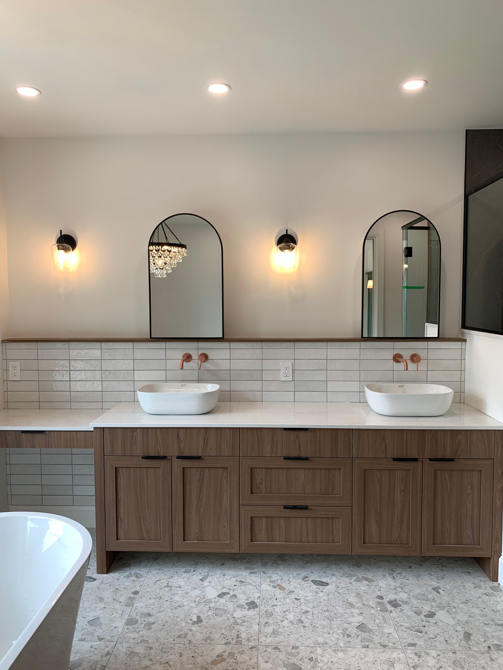 Une salle de bain avec deux lavabos, deux miroirs et une baignoire.