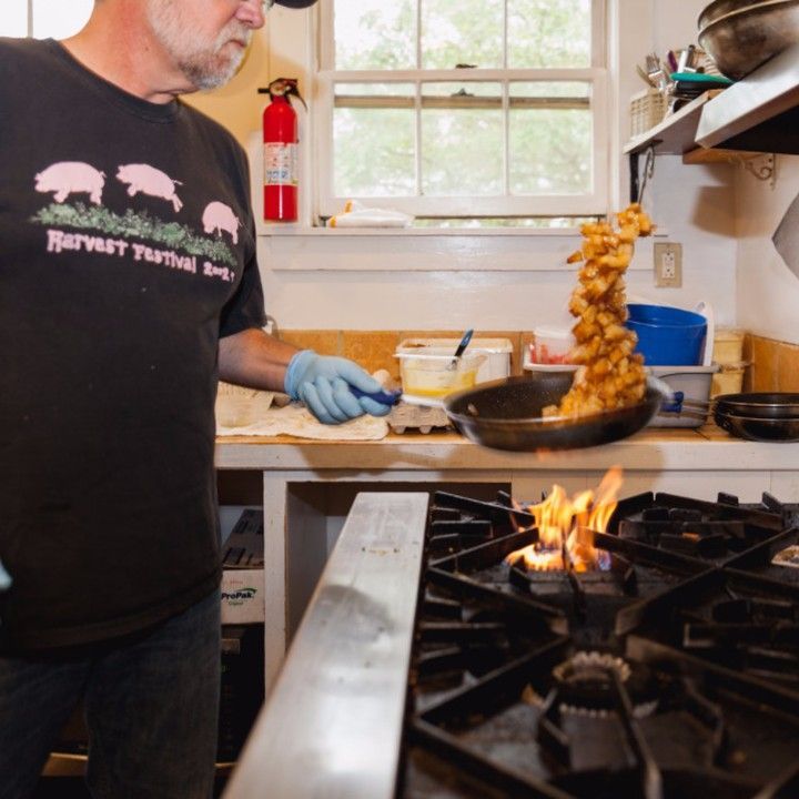 A man wearing a black shirt that says harvest festival