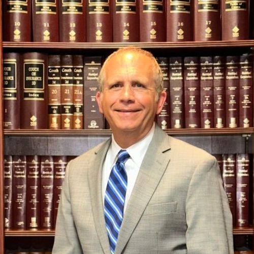 A man in a suit and tie is smiling for the camera.