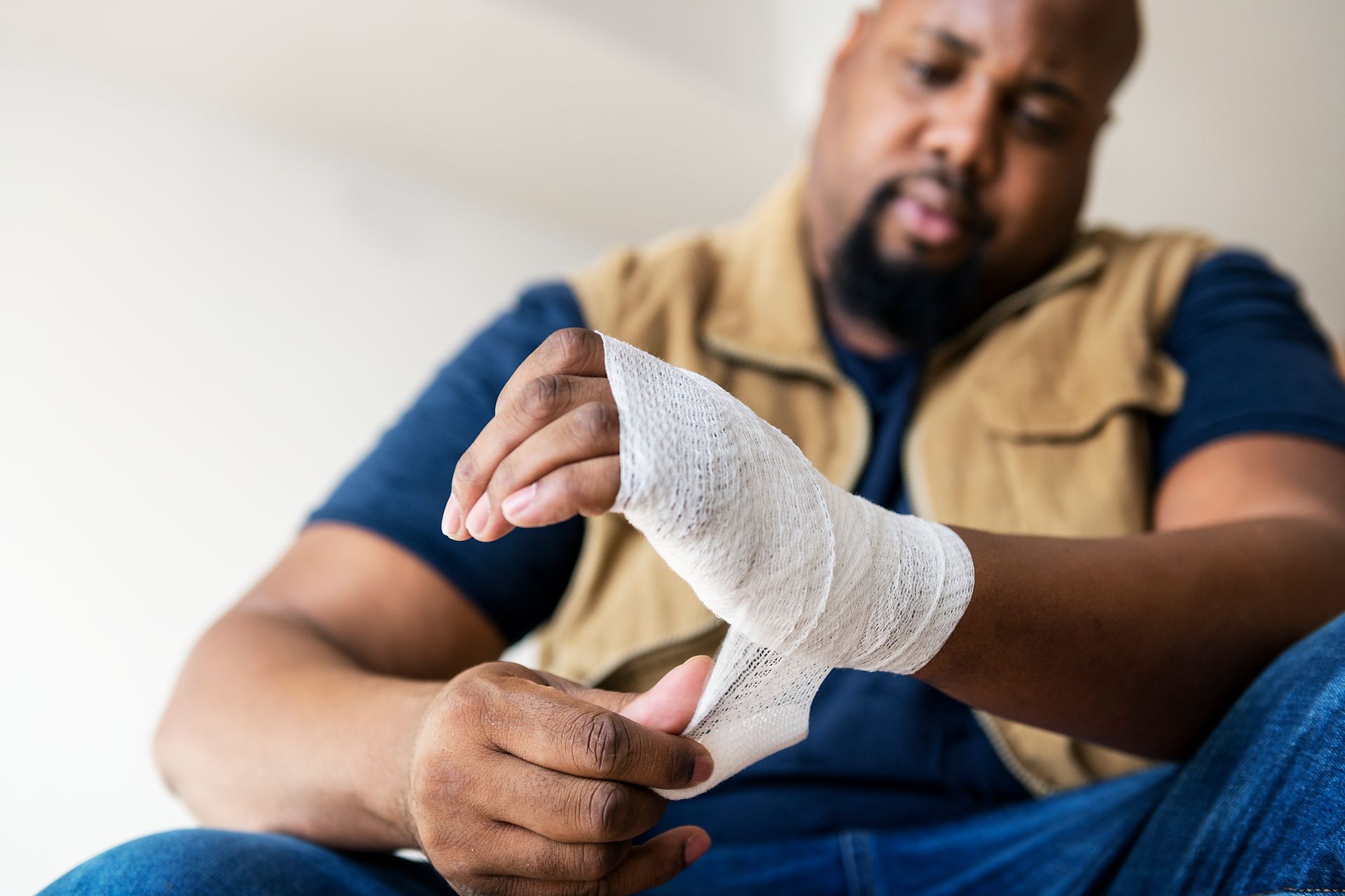 A man is wrapping his wrist with a bandage.