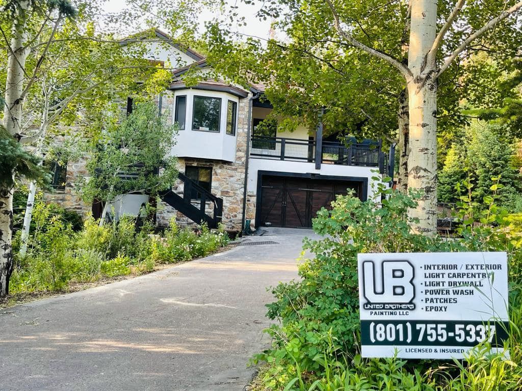 A large house with a for sale sign in front of it.