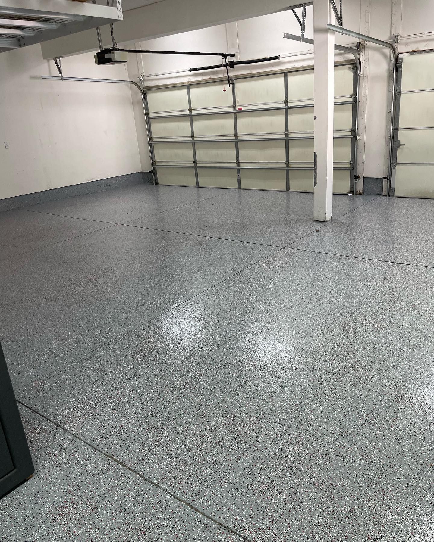 A garage with a garage door open and a gray floor.