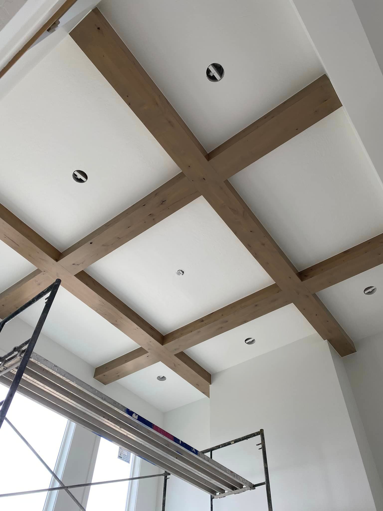 A ceiling with wooden beams and white walls