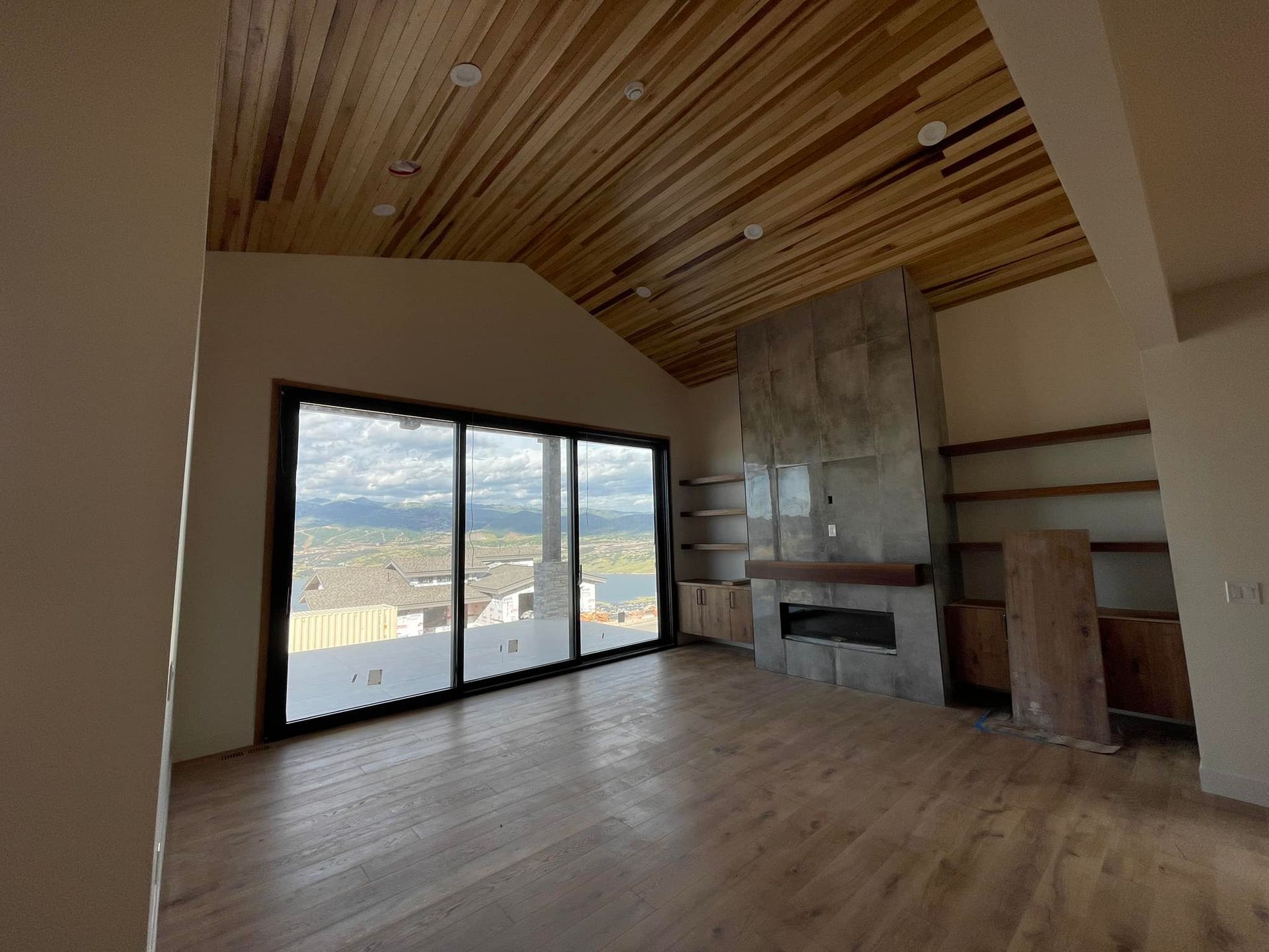 An empty living room with a fireplace and sliding glass doors