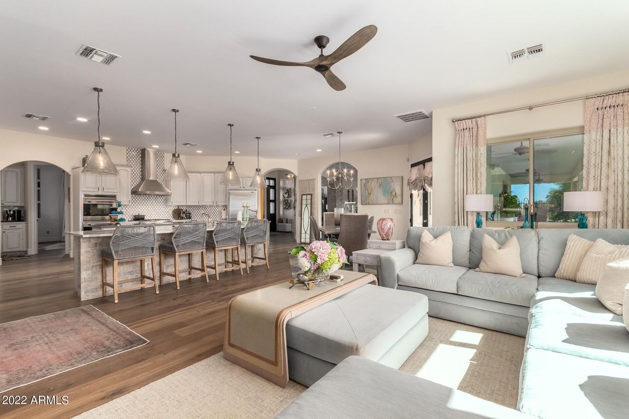 Open-concept living area with a kitchen, living room, and dining space; light blue and neutral tones.