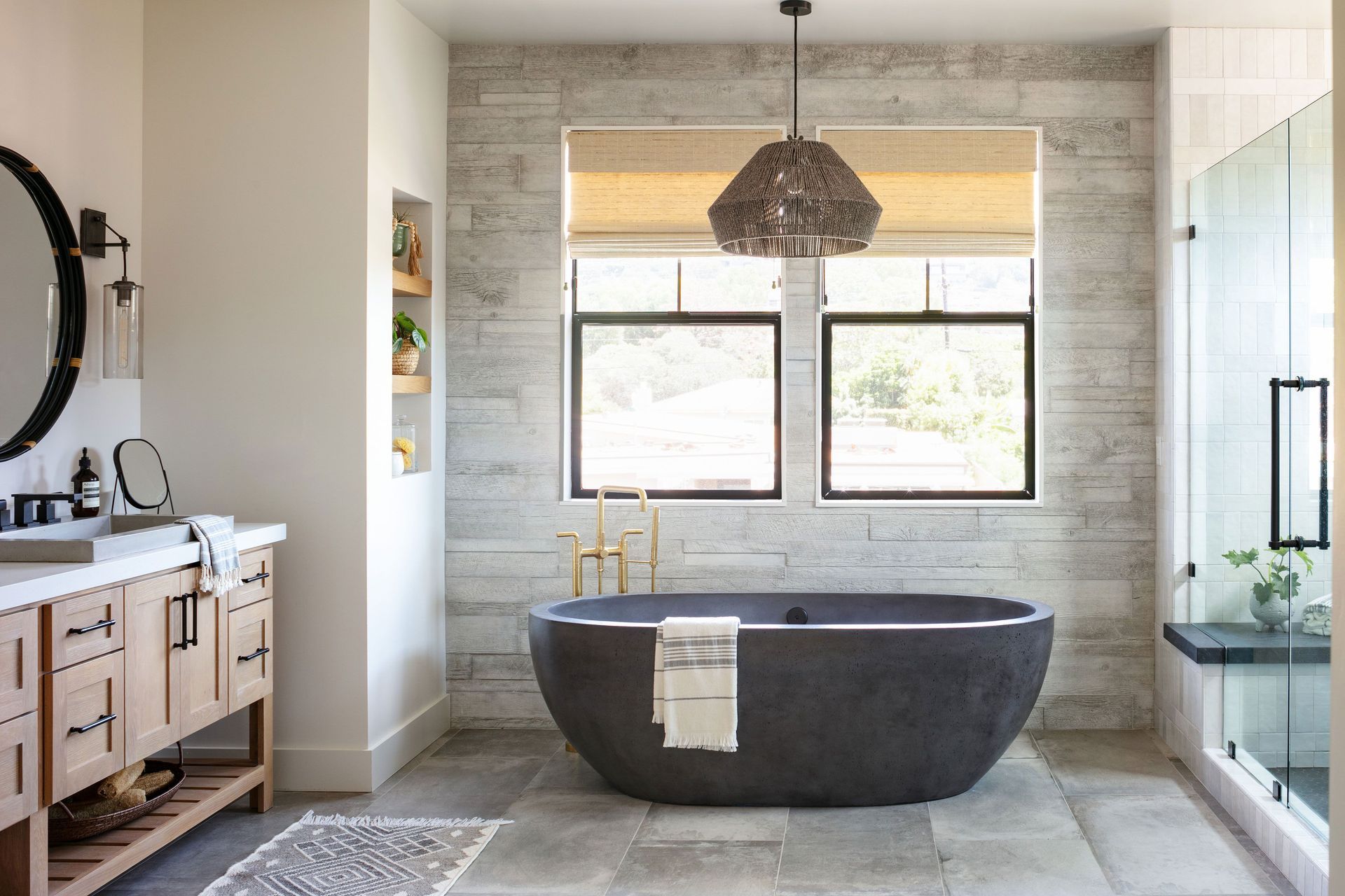 A bathroom with a bathtub , sink , mirror and window.