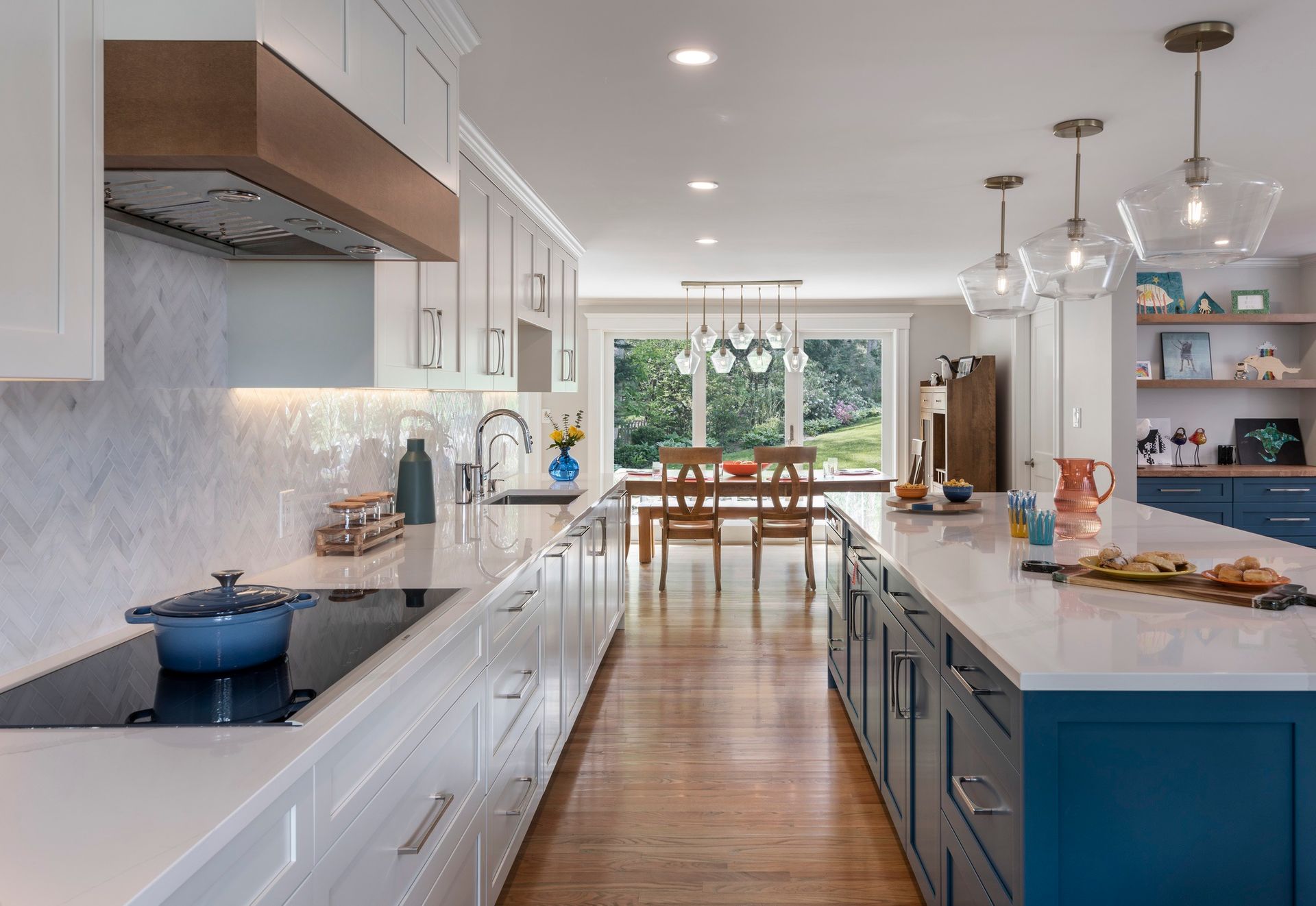 A kitchen with a large island and a pot on the stove.