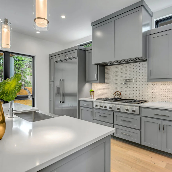A kitchen with gray cabinets and stainless steel appliances