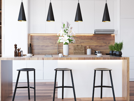 A kitchen with a wooden counter top , white cabinets , and black stools.