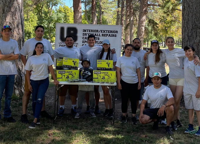 A group of people posing for a picture in front of a sign that says ub