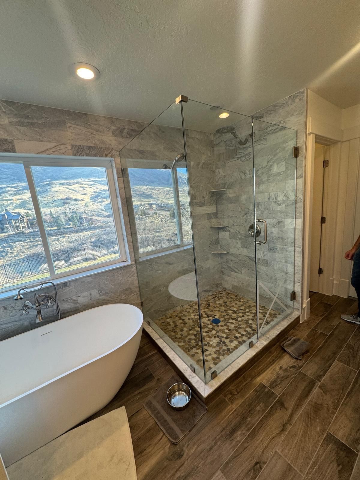 A bathroom with a tub , shower , and window.
