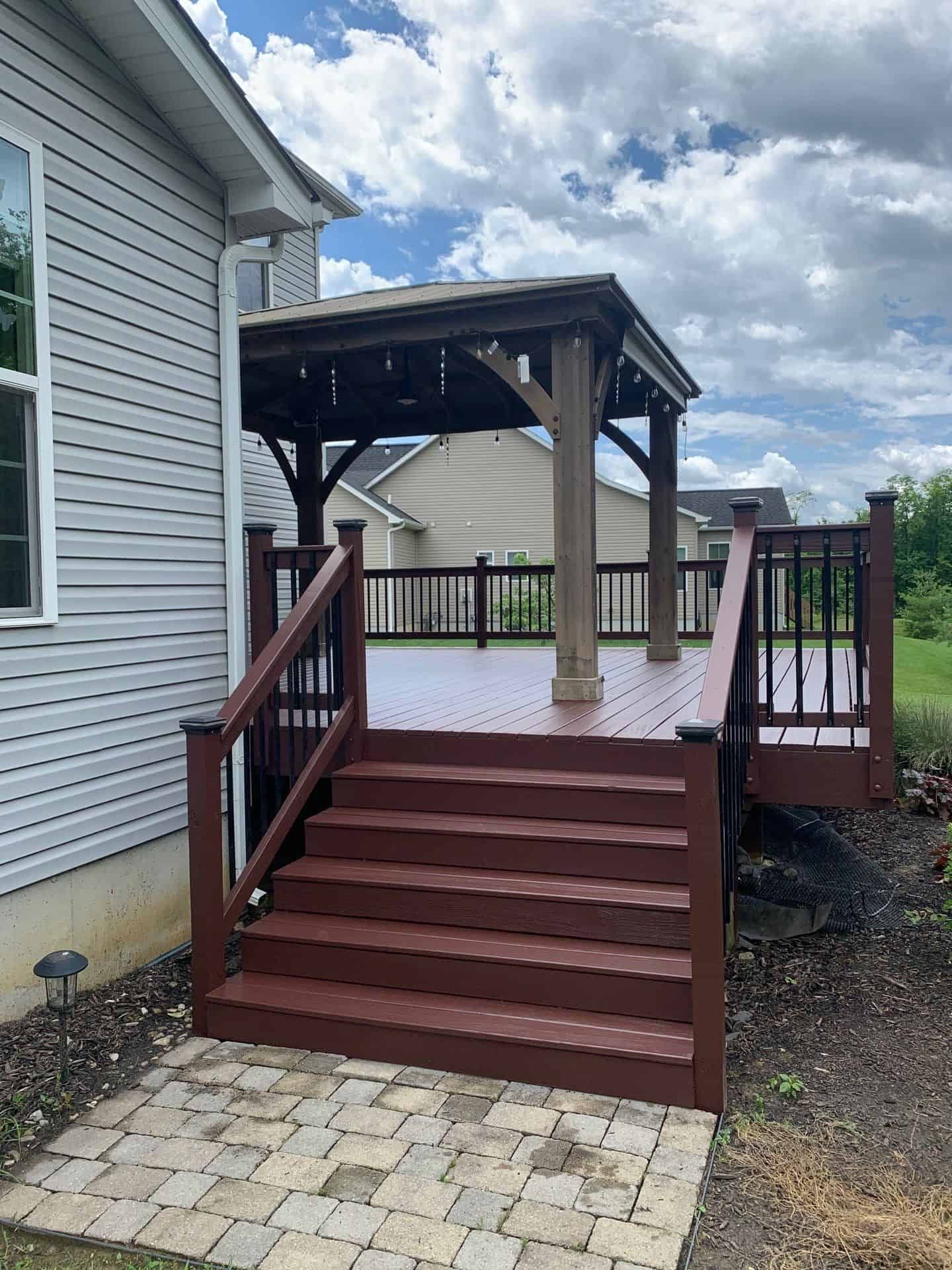 Modern kitchen with white cabinets, dark island, stainless steel appliances, and bar stools.