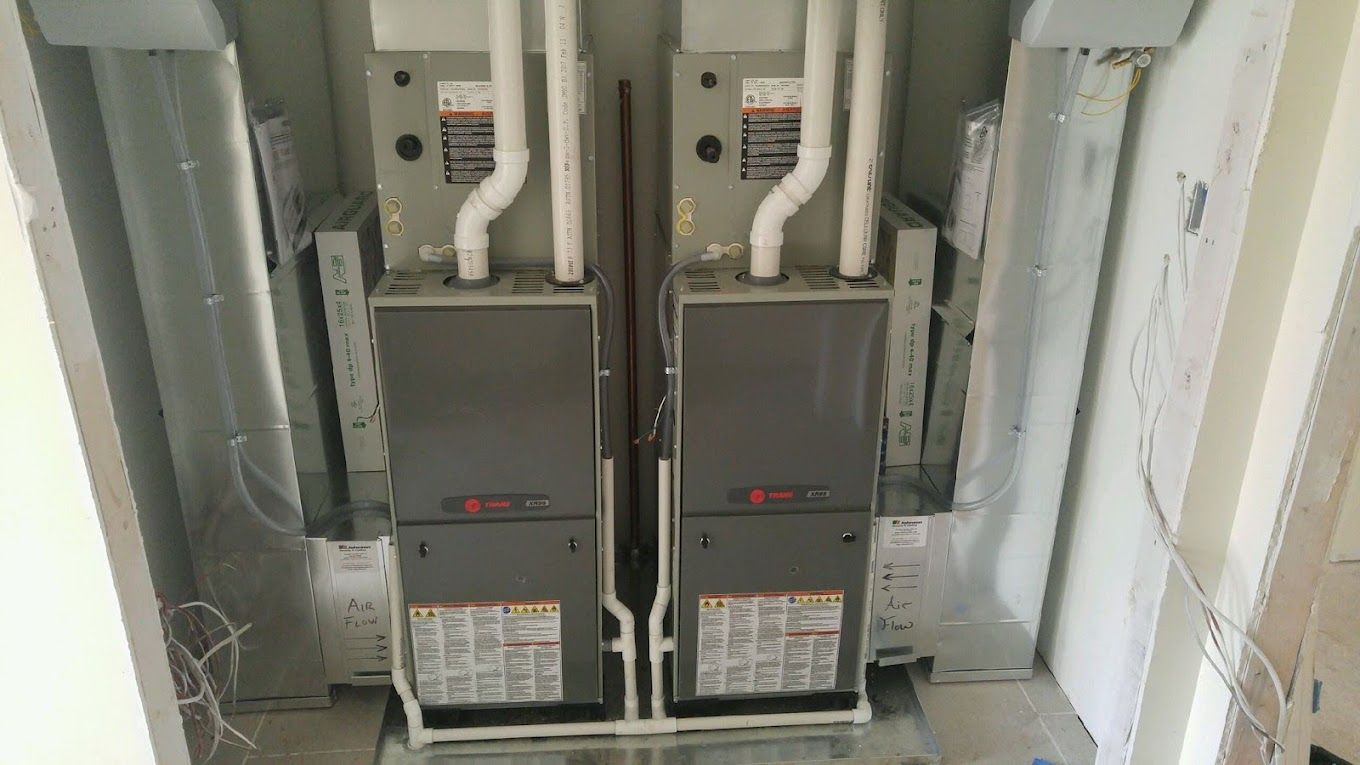 Two Trane air conditioners are sitting next to each other in a room.