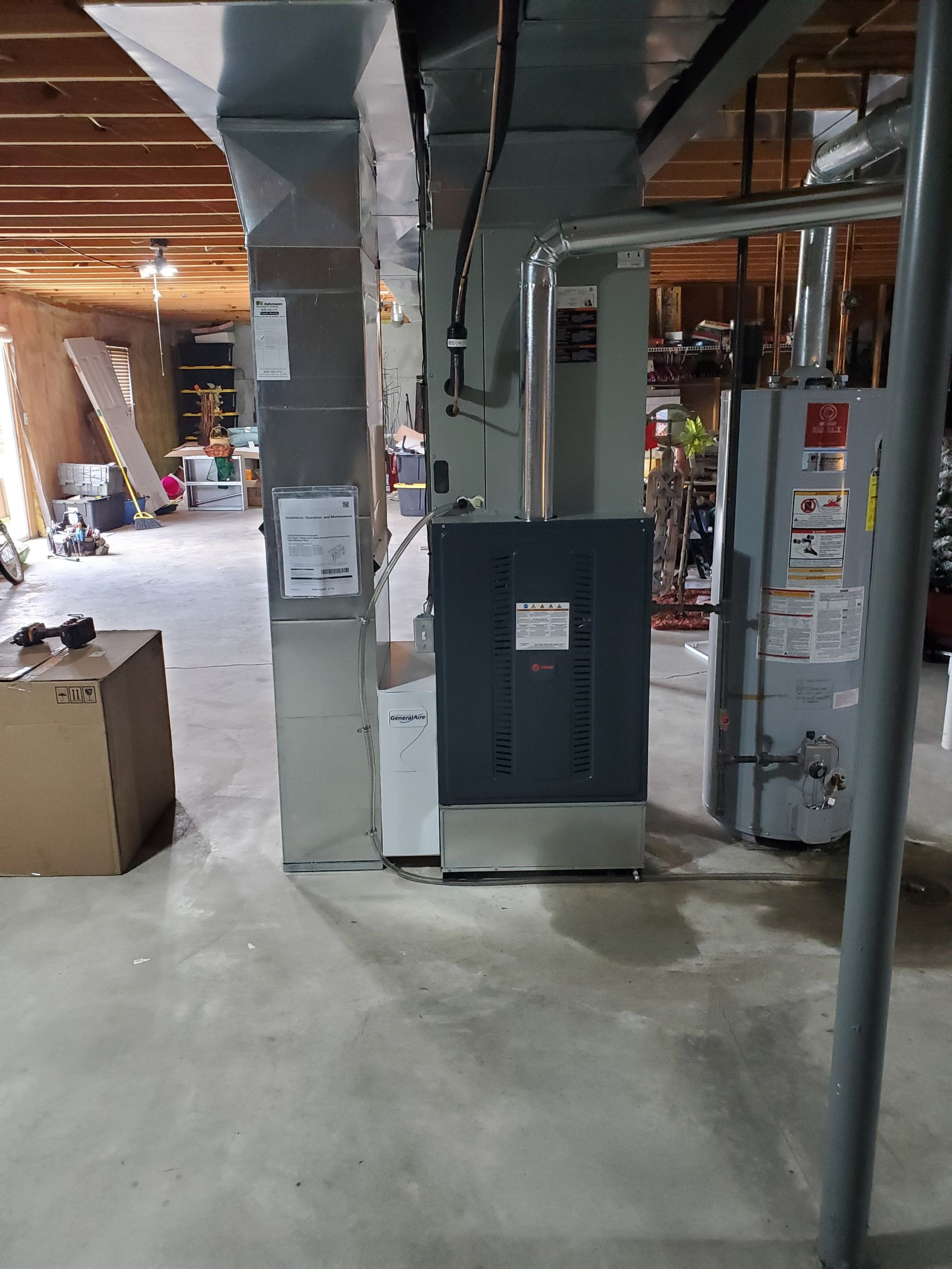 A room with a heater and a box on the floor