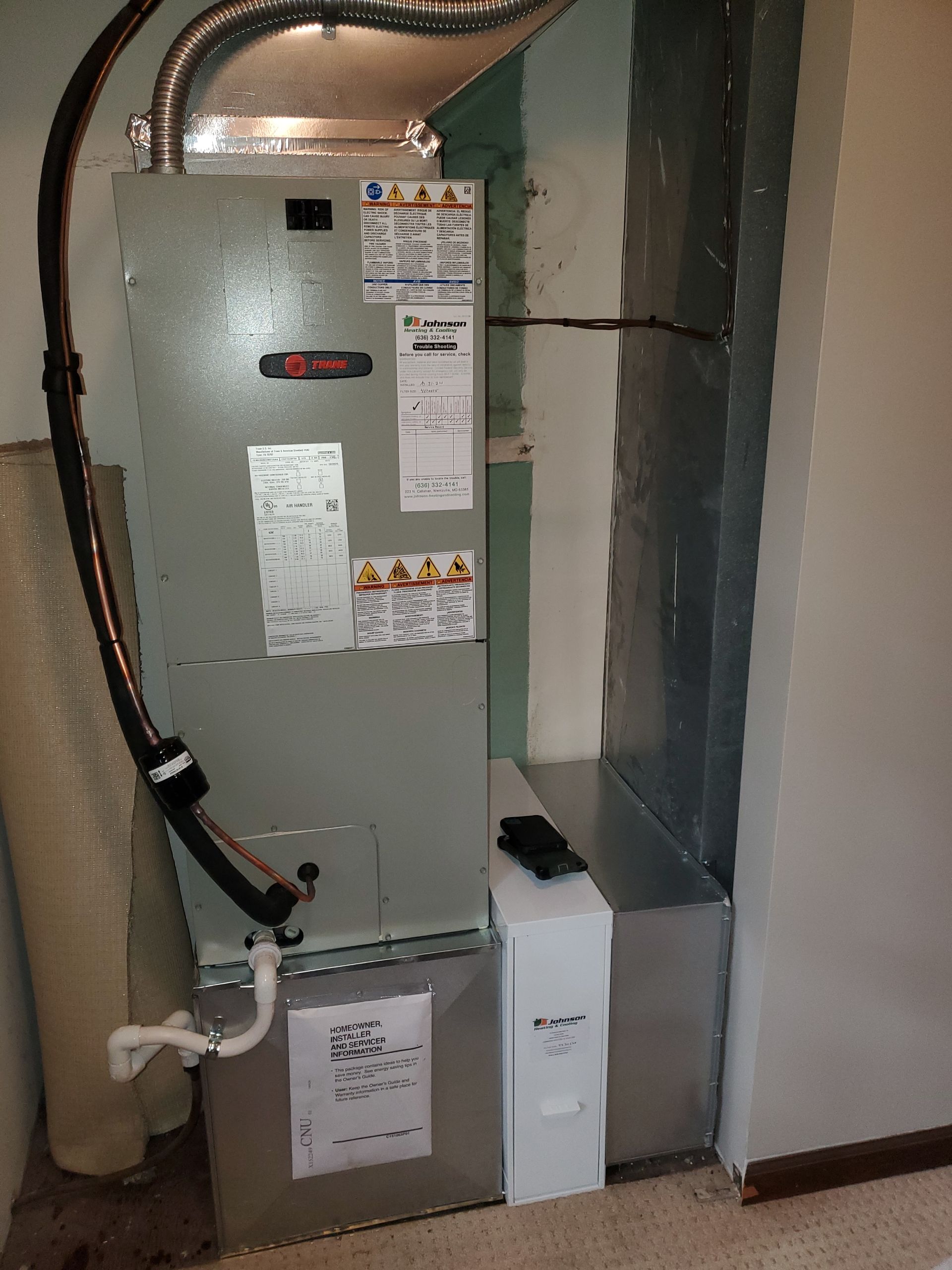 An air conditioner is sitting in a room next to a wall.