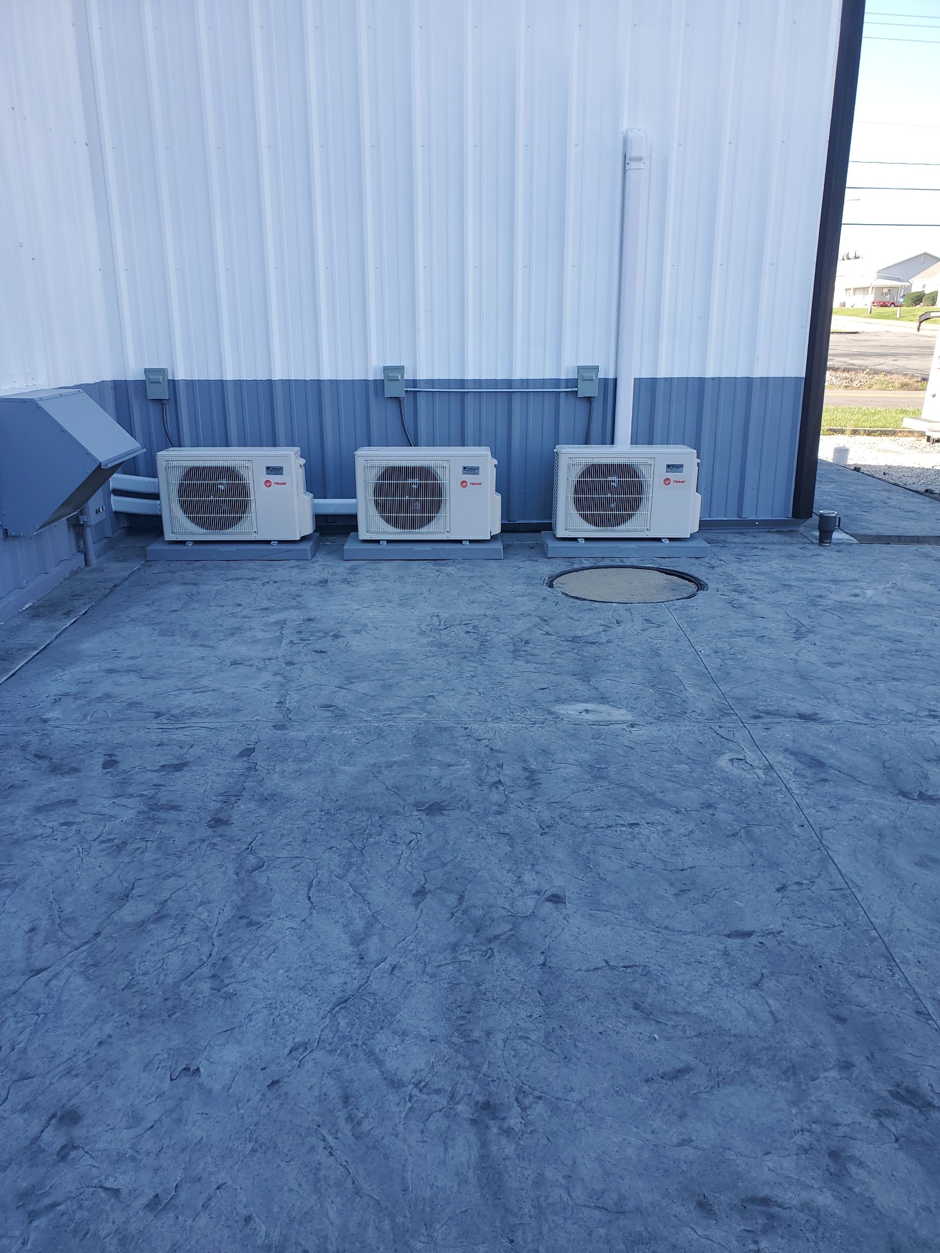 Three air conditioners are sitting on the roof of a building. mini-splits