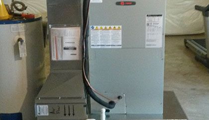 A heater is sitting on top of a metal table next to a water heater.
