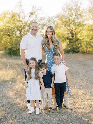 A family is posing for a picture in a field.