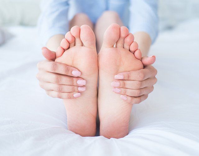 Woman Holding Her Foot — Lake Orion, MI — Associated Foot Clinic Of Lake Orion PC
