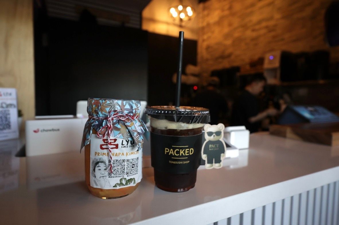 Coffee cans displayed on a counter in a warm, softly lit café interior