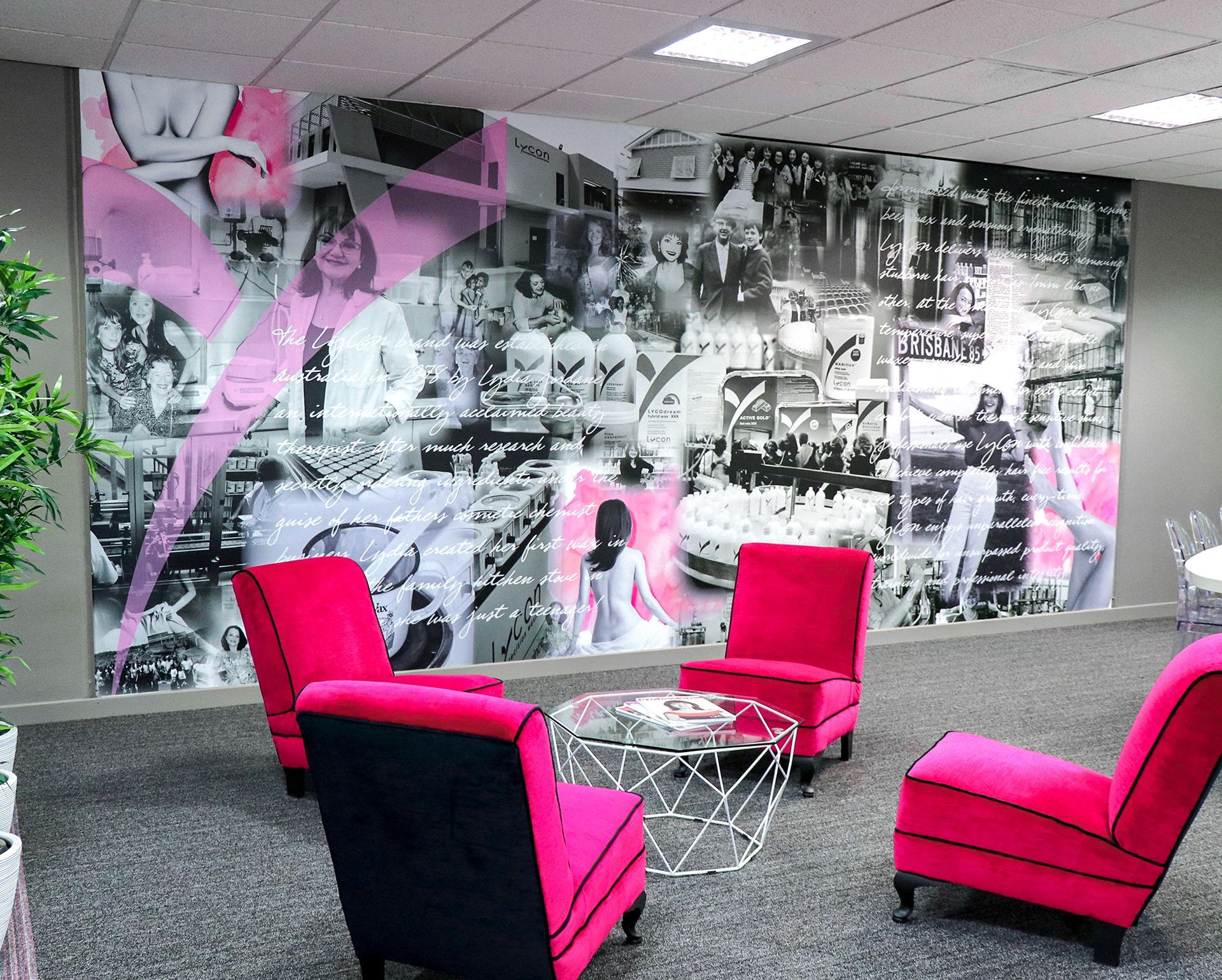 A room with pink chairs and a collage of pictures on the wall.