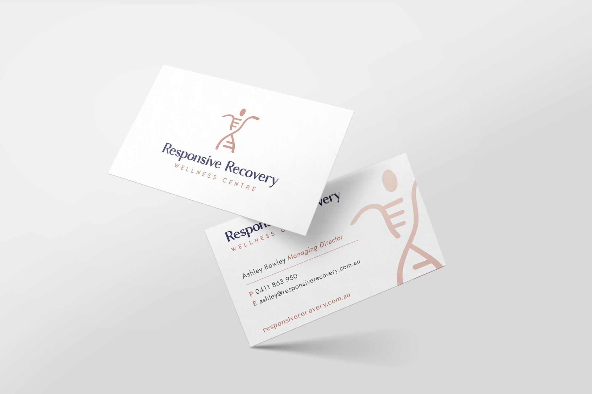 Two business cards are floating in the air on a white surface.