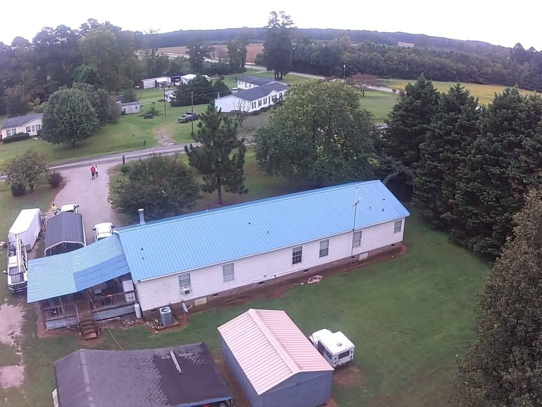 An aerial view of a mobile home with a blue roof