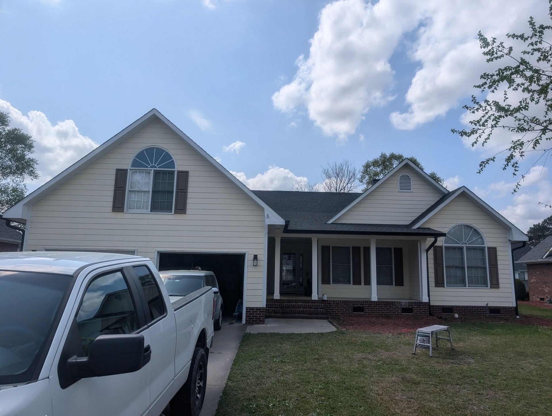 A white truck is parked in front of a house.