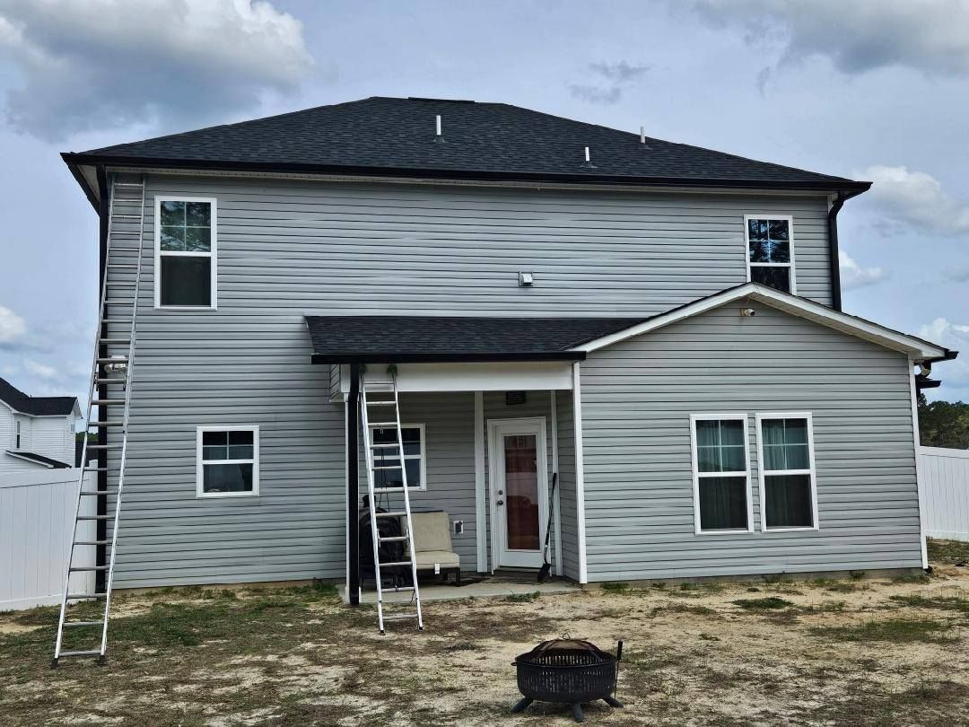 The back of a house with a ladder on the side of it.